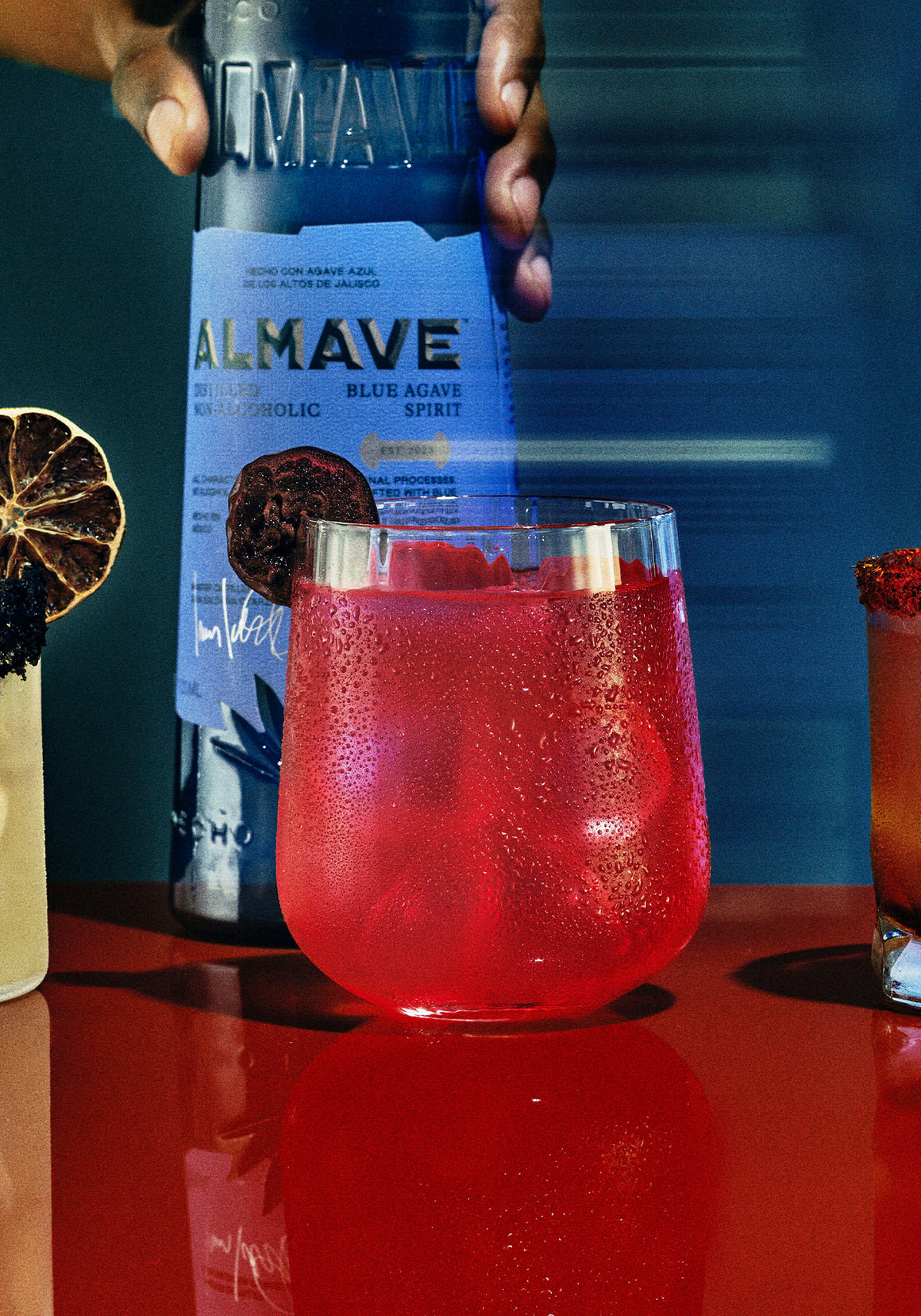 photo of golden hour margarita cocktail with almave blanco bottle behind